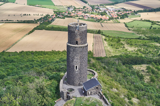 Arieal view of stone tower of ruined medieval gothic castle Hazmburk placed on the top of big mountain in north west bohemian region in Czech Republic. Picture is taken in summer sunny afternoon.