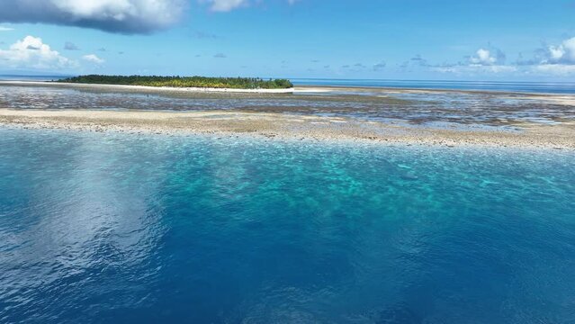 Clear water covers a beautiful reef surrounding the remote island of Koon near Seram, Indonesia. This scenic island's coral reefs, and the surrounding seas, support extraordinary marine biodiversity.