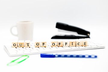An office setting with wooden letter cubes illustrating an &lsquo;Out of office&rsquo; message.