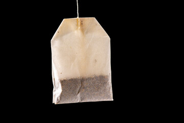 white translucent tea or infusion sachet on black color background.