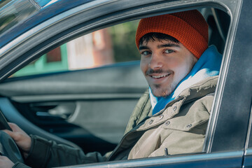 young man driving behind the wheel of the car