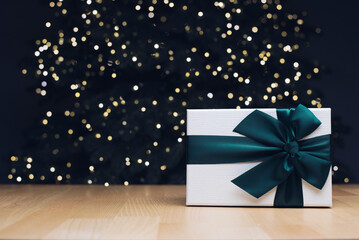 Gift. A box with a bow. Christmas and New Year's gift on the background of a Christmas tree.