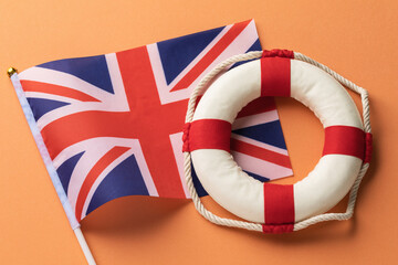 UK  flag and lifebuoy on a colored background, concept on the theme of help from UK