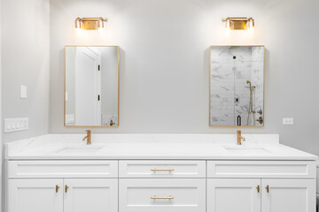 A luxurious, white master bathroom with gold hardware and faucets. No brands or labels.