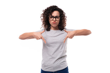 young smiling brunette curly woman dressed in a gray basic corporate color t-shirt with print mockup