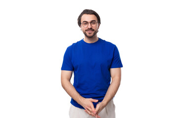 young confident brunette man with a beard dressed in a blue t-shirt on a studio white background