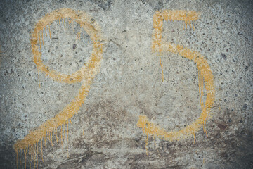 Yellow numbers on a concrete wall, number 95