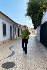 Young woman walking on the street in the old town of Tavira, Portugal