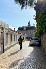 Fototapeta na wymiar woman walking on a cobblestone street in the old town of Lisbon, Portugal