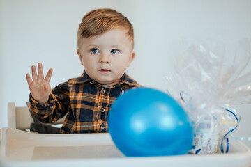 Fototapeta na wymiar Toddler celebrating birthday playing with balloon