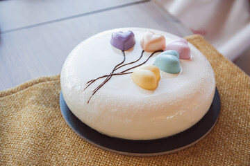 A beautiful wedding cake decorated with small colored hearts