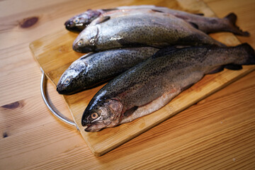 Fresh trouts on the wooden board.
