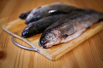Fresh trouts on the wooden board.