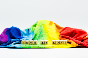 Pride month celebration setting with wooden letter cubes forming the slogan &lsquo;Love is love&rsquo;