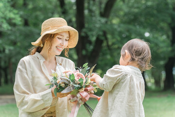 ママに花束をプレゼントする女の子・公園で遊ぶ親子・家族・ファミリー
