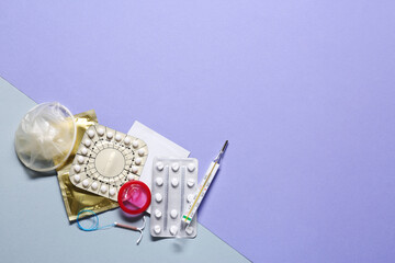 Contraceptive pills, condoms, intrauterine device and thermometer on color background, flat lay with space for text. Different birth control methods