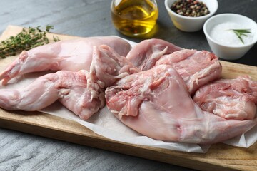 Fresh raw rabbit legs on black table, closeup