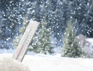 Weather thermometer under falling snow outdoors on winter day, space for text