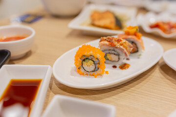 Fototapeta na wymiar sushi and california maki on white dish, Japanese food culture