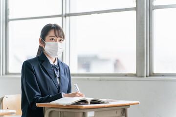 学校の教室でマスクをしている高校生・中学生・女子高生
