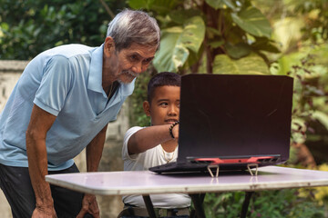 A young tech savvy Filipino boy teaches his grandfather how to use the laptop and use social media....
