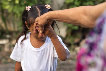 A respectful young girl does the mano po gesture to his grandmother. A sign of respect and...