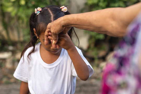 A respectful young girl does the mano po gesture to his grandmother. A sign of respect and reverence to your elders in the philippines.