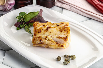 Roasted cod fish steak with salad