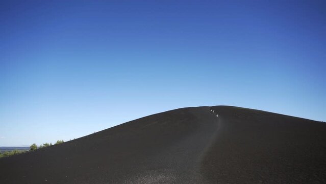 Distant People walking up cinder cone in Craters of the Moon