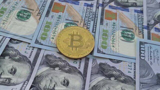 Symbolic coins of bitcoin on banknotes of one hundred dollars. Exchange bitcoin cash for a dollar