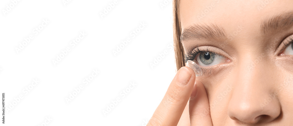 Wall mural young woman putting in contact lenses on white background, closeup. banner for design