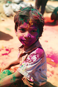 Indian child adorned with Holi Festival powder colors, childhood innocence