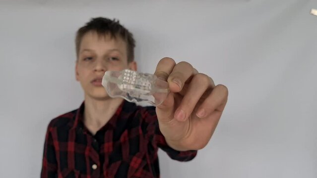 Man smiling holding dental aligner retainer in hand invisible concept