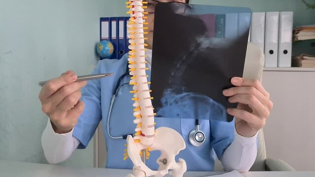 Traumatologist examines x-ray of person spine. Spinal hernia