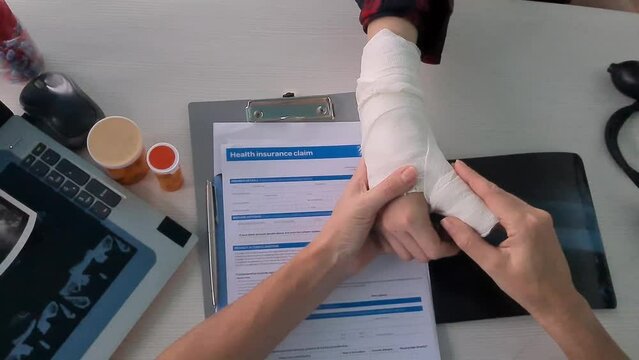 Broken arm at doctor appointment in clinic. Concept of drug treatment of intra-articular fractures and medical insurance