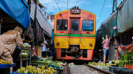 Maeklong Railway Market Thailand, tourist taking photos with mobile of the Fresh Market on the Railroad Track Mae Klong Train Station Bangkok 