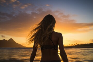 Fototapeta premium Silhouette of a beautiful woman in bikini on the beach at sunset, Female surfer rear view in the sea at sunset, Oahu, Hawaii, United States of America, AI Generated
