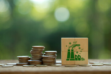 Carbon Tax, Tax on carbon emission. Coins stack with CO2 icons on wooden cubes for Environmental and social responsibility businesses. Taxation for nature pollution.Carbon credit.ESG fund, CO2 tax,