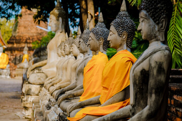 Ayutthaya, Thailand Wat Yai Chaimongkol with a Buddha statue outside the temple, Ayutthaya Historical Park covers the ruins of the old city of Ayutthaya, Phra Nakhon Si Ayutthaya Province, Thailand - obrazy, fototapety, plakaty