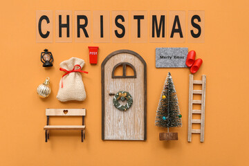 Beautiful composition with door, ladder, Christmas tree and decorations on orange background
