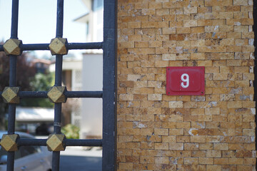 house number six. Decorative lettering on a brick wall.