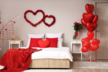 Interior of light bedroom decorated for Valentine's Day with hearts, balloons and roses
