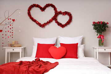 Interior of light bedroom decorated for Valentine's Day with hearts and roses