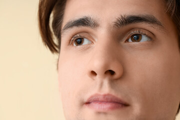 Young man with brown eyes on beige background, closeup. Glaucoma awareness month