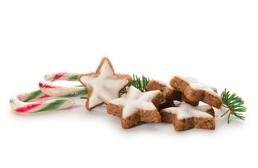 Composition with delicious stars shaped Christmas cookies, candy canes and fir tree branch on white background