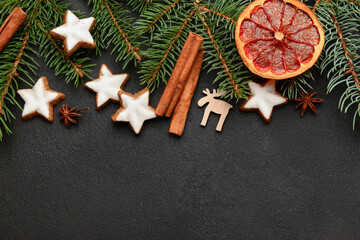 Obraz na płótnie Canvas Composition with delicious stars shaped Christmas cookies, spices, orange dried piece and fir tree branches on dark background