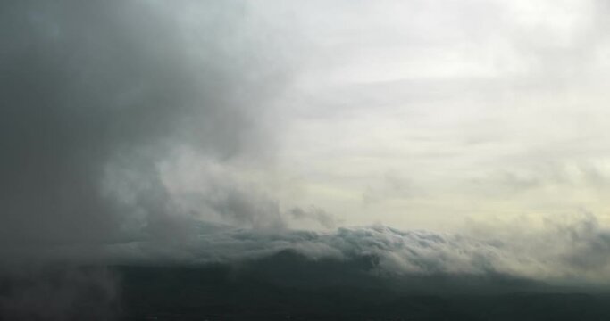 Top view of the clouds that lie on the hills and swirl. Strong wind. Autumn. Winter