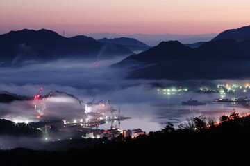 海霧が漂う造船所の夜明け