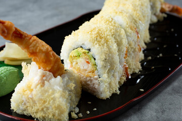 A closeup view of a crunch roll sushi plate.