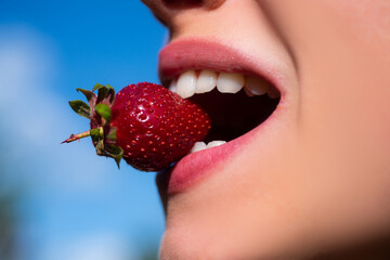 Summer sexy fruits. Strawberry in lips. Red strawberry in woman mouths close up.